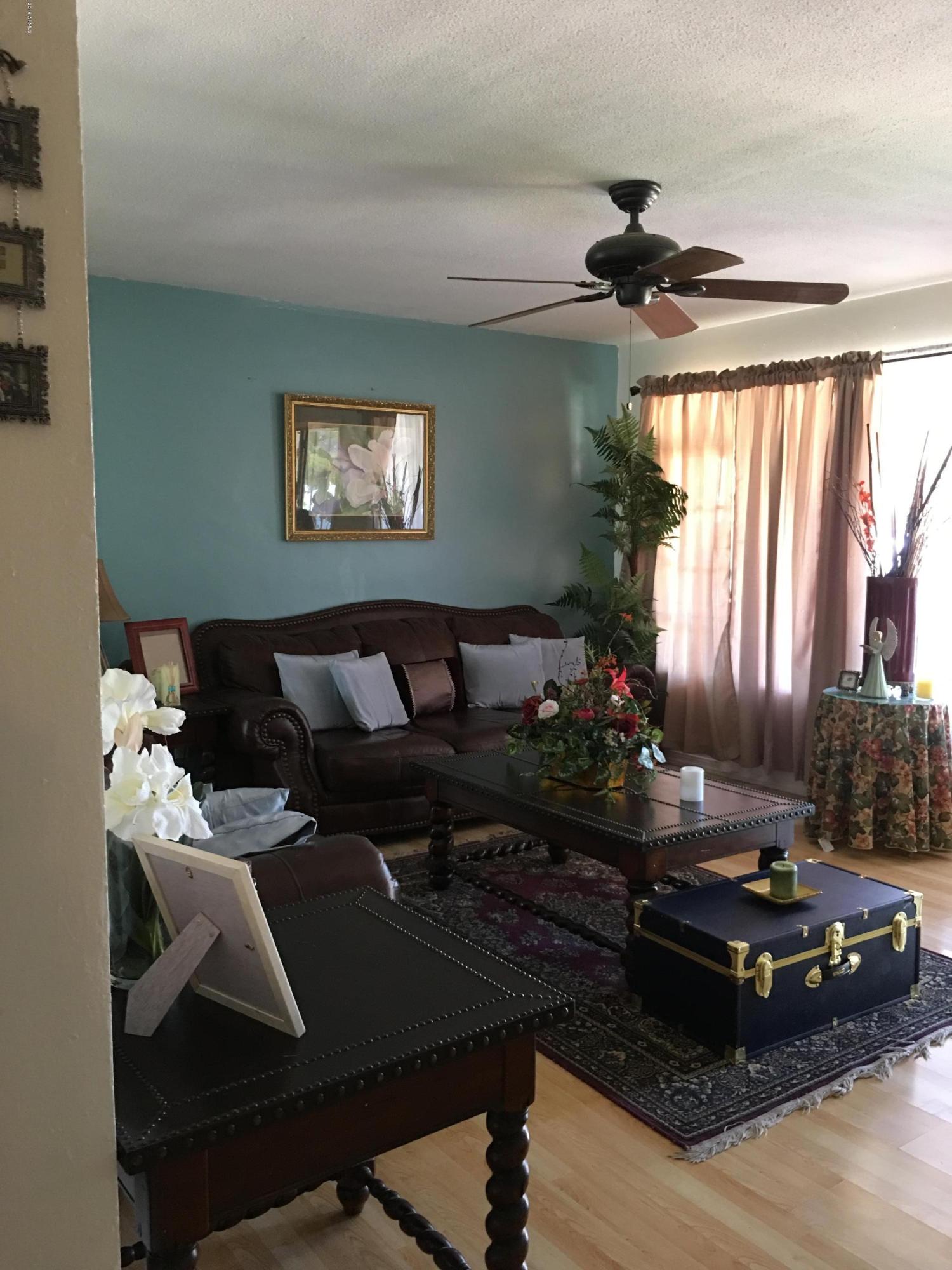 3725 West Lawrence Road Phoenix, AZ 85019 - Photo 8 of 24 a living room with furniture and a floor to ceiling window