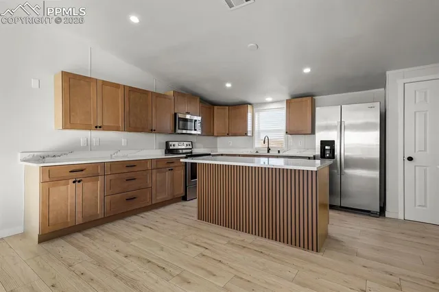 a kitchen with stainless steel appliances granite countertop a refrigerator sink and cabinets