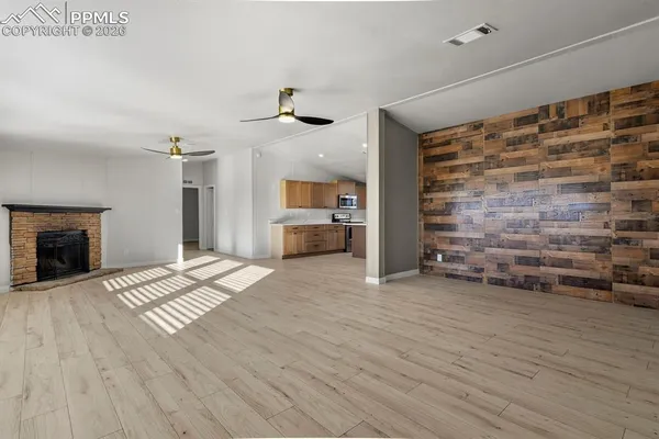 a view of empty room with wooden floor and fireplace