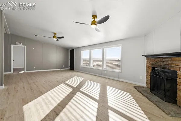 a view of an empty room with a fireplace and a window