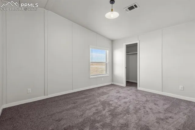 an empty room with an entryway and fan