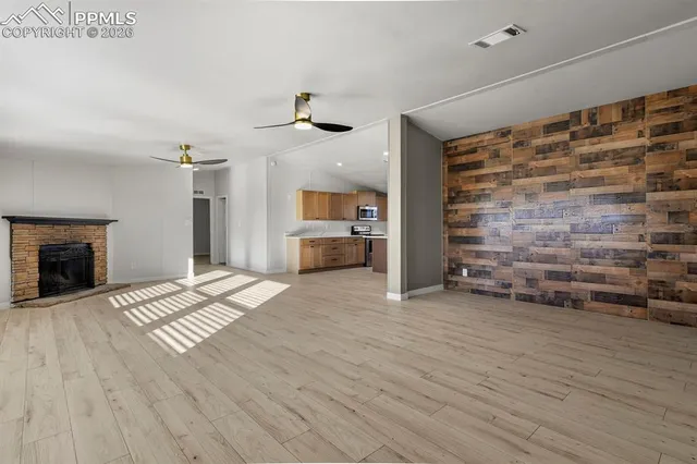 a view of empty room with wooden floor and fireplace