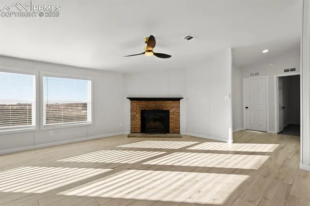 a view of an empty room with a fireplace and a window
