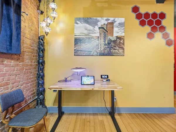 a view of a workspace with furniture and wooden floor