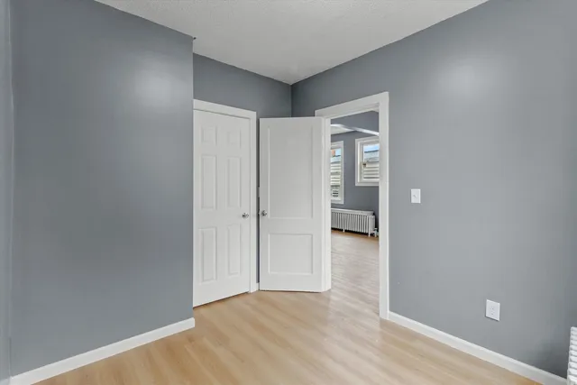a view of empty room with wooden floor
