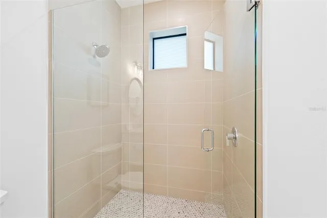 a bathroom with a sink a mirror a vanity and a shower
