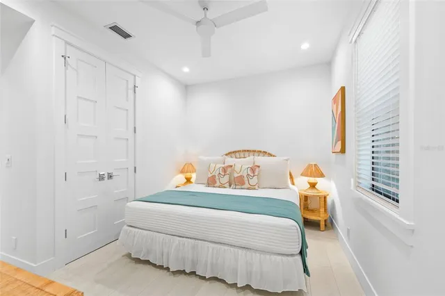 a bedroom with a large bed and a flat tv screen on dresser