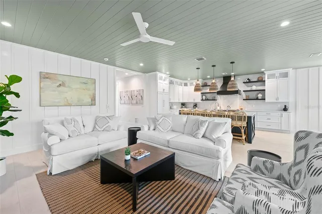 a living room with furniture and a view of kitchen