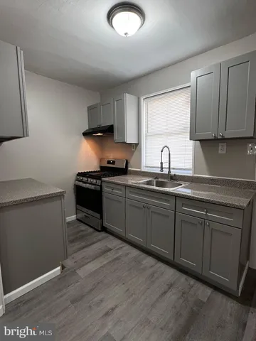a kitchen with granite countertop a sink cabinets and stainless steel appliances