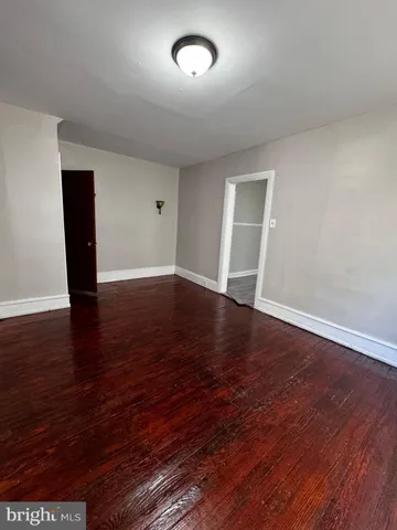 a view of a livingroom with wooden floor and bathroom