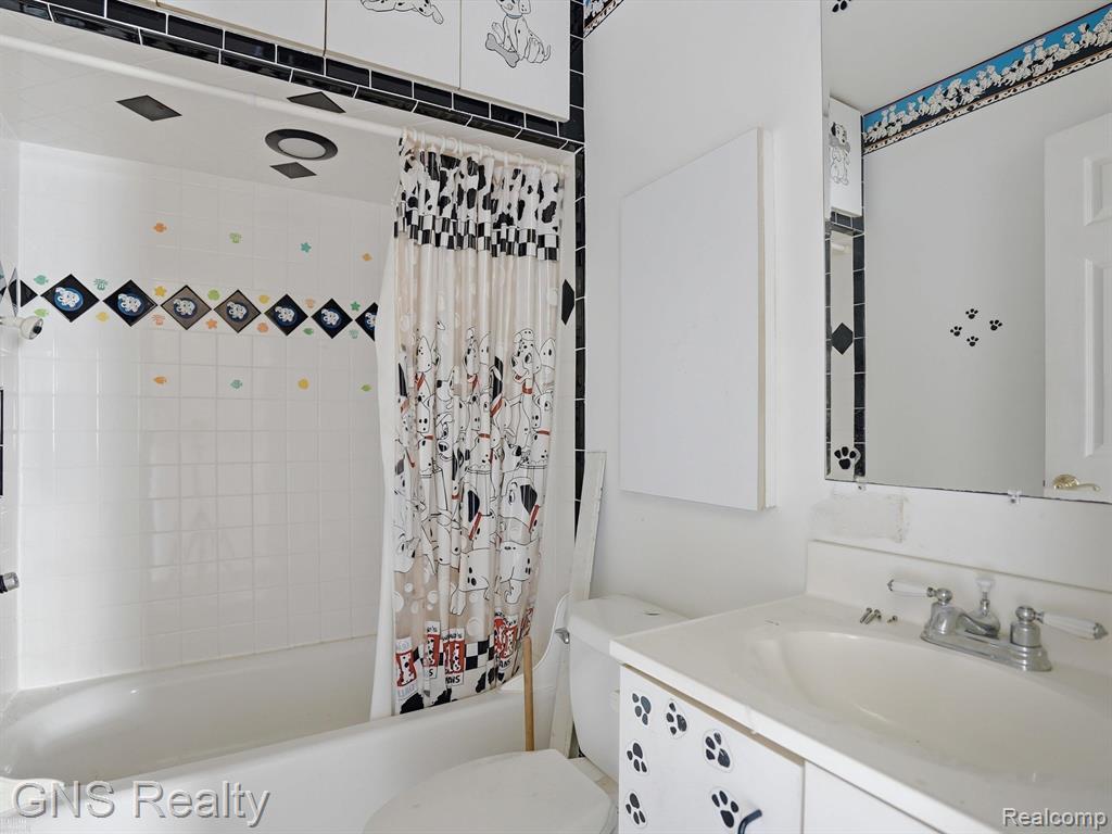 2717 Normandy Road Royal Oak, MI 48073 - Photo 13 of 13 Bathroom featuring a white bathtub, ceramic tile surround with decorative accents, a built-in vanity with integrated sink, and a wall-mounted mirror
