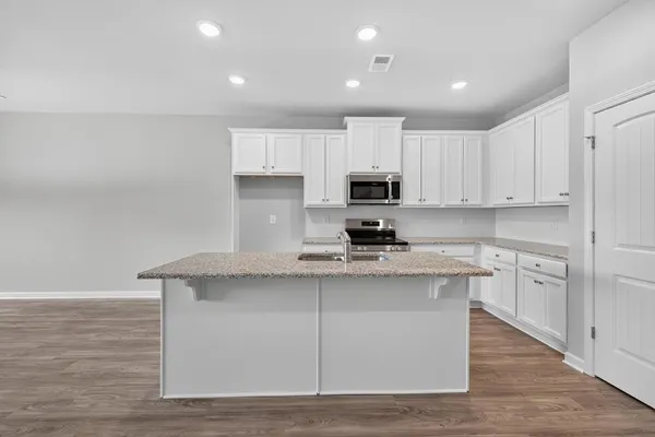 a kitchen with granite countertop white cabinets and a sink