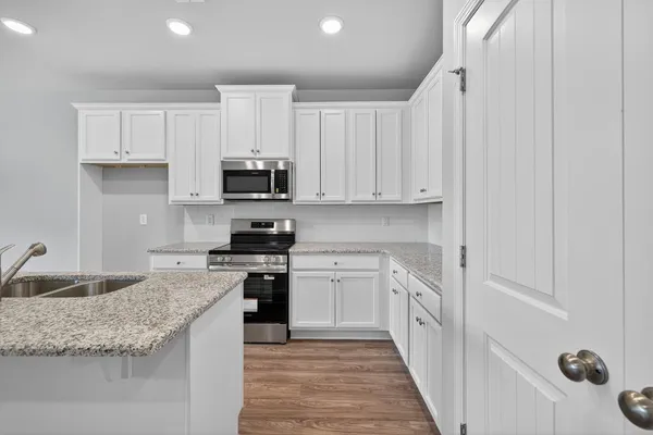 a kitchen with granite countertop a sink and stove