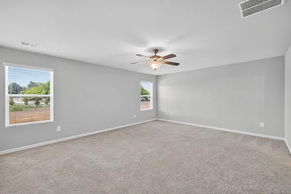 a view of an empty room with a chandelier fan