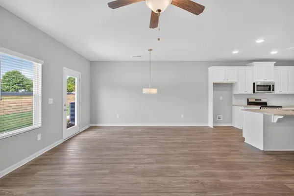 a view of kitchen with granite countertop cabinets and wooden floor