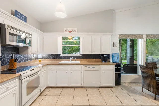 a kitchen with a stove sink and cabinets