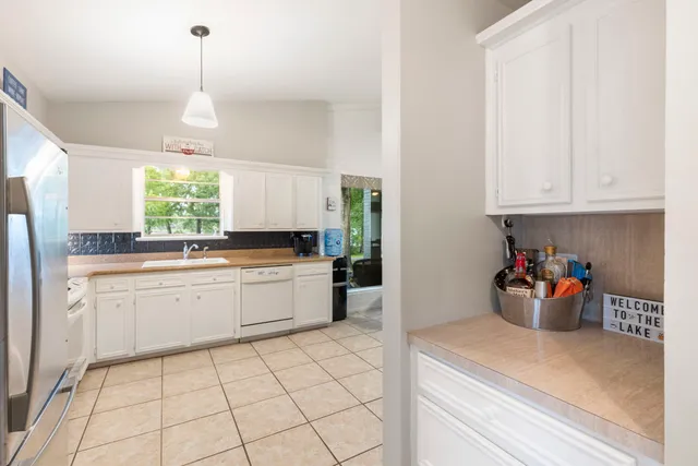 a kitchen with stainless steel appliances white cabinets and a window