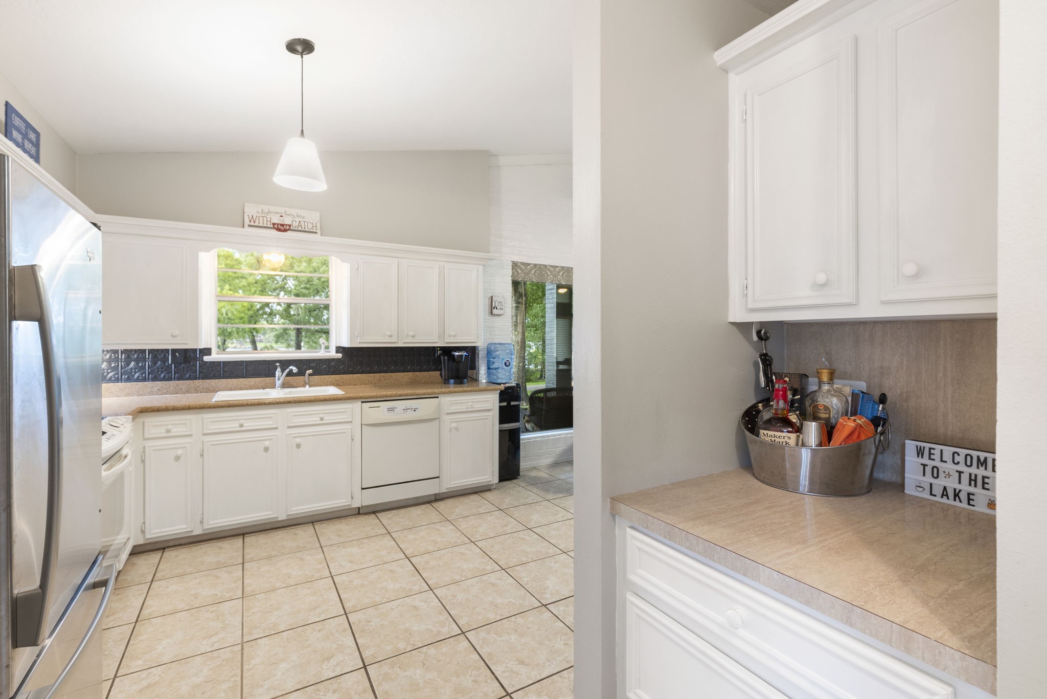 245 Lakeland Road Huntsville, TX 77320 - Photo 17 of 49 a kitchen with stainless steel appliances white cabinets and a window