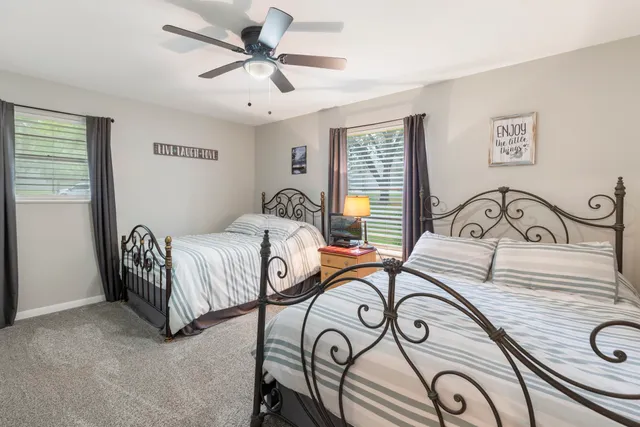 a bedroom with a bed a chandelier and a window