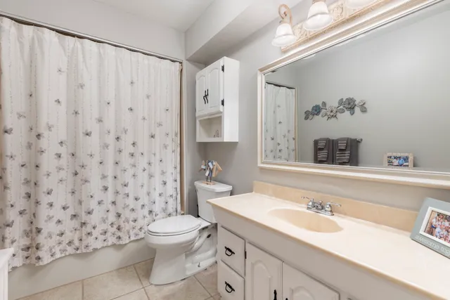 a bathroom with a sink a toilet and shower curtain