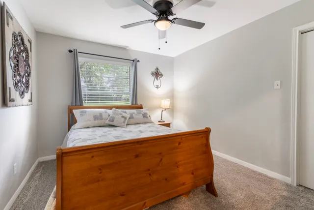 a bed sitting in a bedroom next to a window