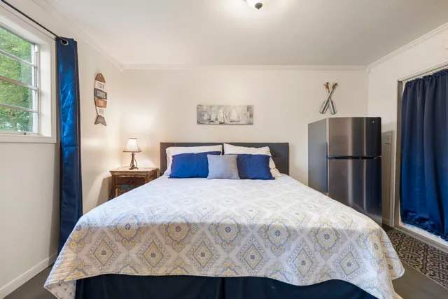 a bedroom with a bed and a refrigerator