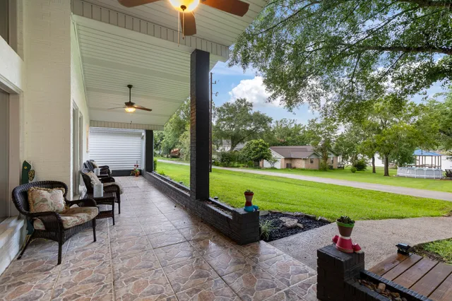 a view of a patio with couches chairs and a big yard