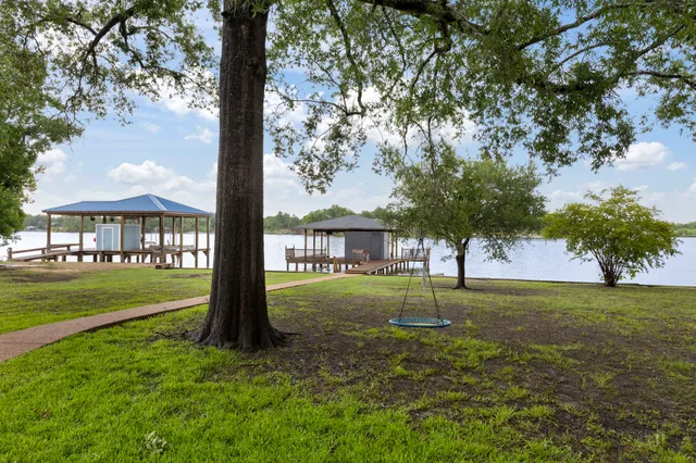 a view of a big yard next to a house with large trees