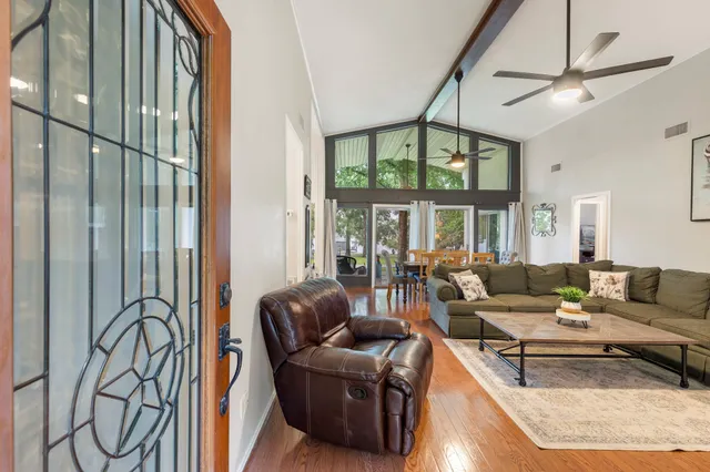 a living room with furniture a ceiling fan and a window