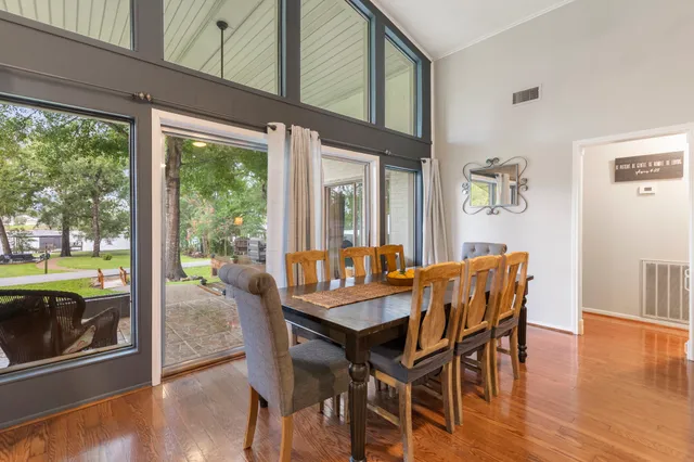 a view of a dining room with furniture large windows and wooden floor