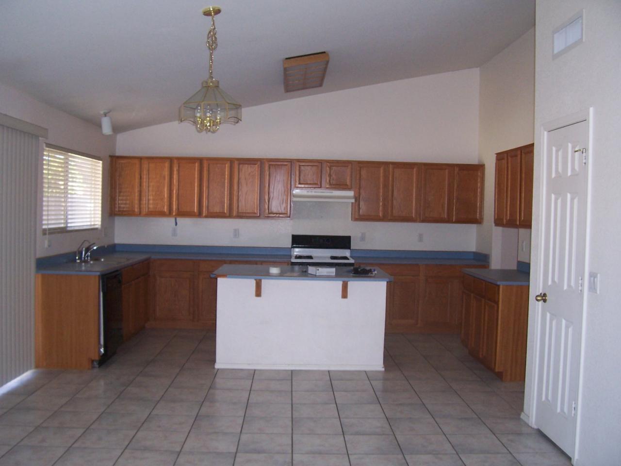 1624 East Carter Road Phoenix, AZ 85042 - Photo 3 of 5 a kitchen with granite countertop a stove a sink and a microwave