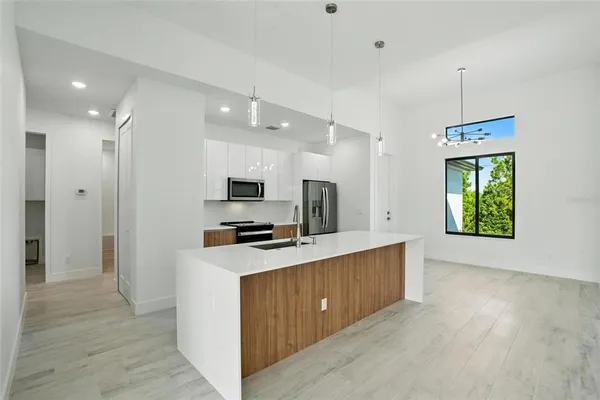 a large kitchen with stainless steel appliances a refrigerator and a stove