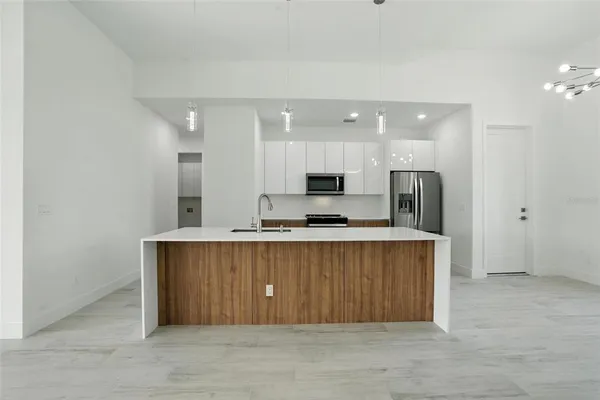 a kitchen with stainless steel appliances granite countertop a refrigerator a sink a stove a microwave and island