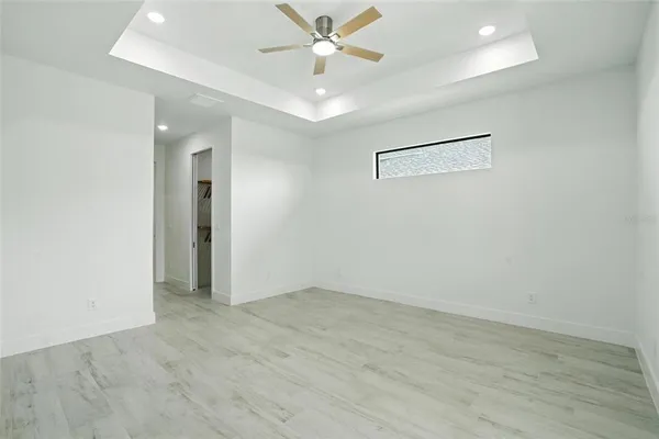 an empty room with a window and a ceiling fan
