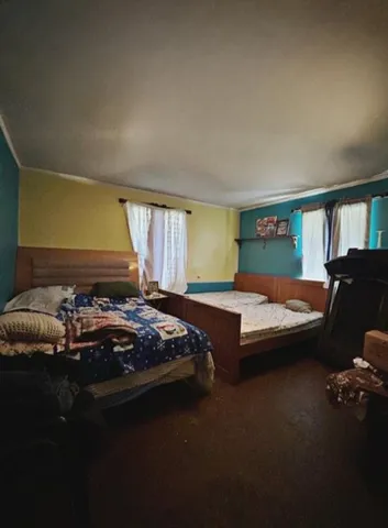 a bedroom with a bed dresser and a window