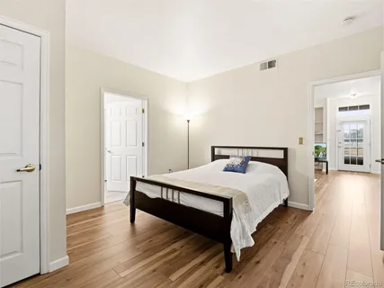 a bedroom with a bed and wooden floor