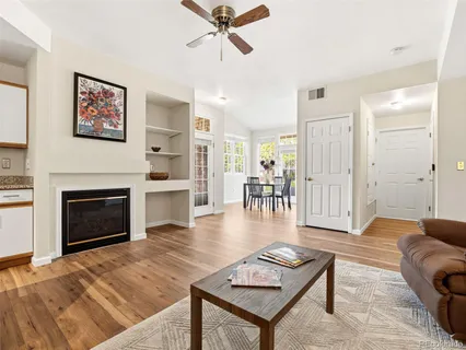 a living room with furniture a fireplace and wooden floor