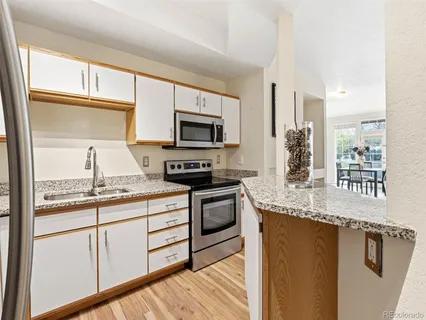 a kitchen with stainless steel appliances granite countertop a stove a sink and a microwave