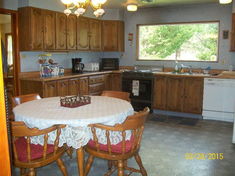 5015 Waldo Road Cave Junction, OR 97523 - Photo 5 of 35 a kitchen with a table chairs and window