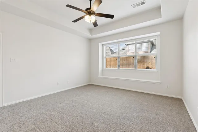 an empty room with a window and a fan