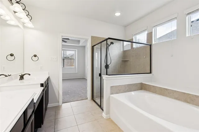 a bathroom with a tub a sink and mirror