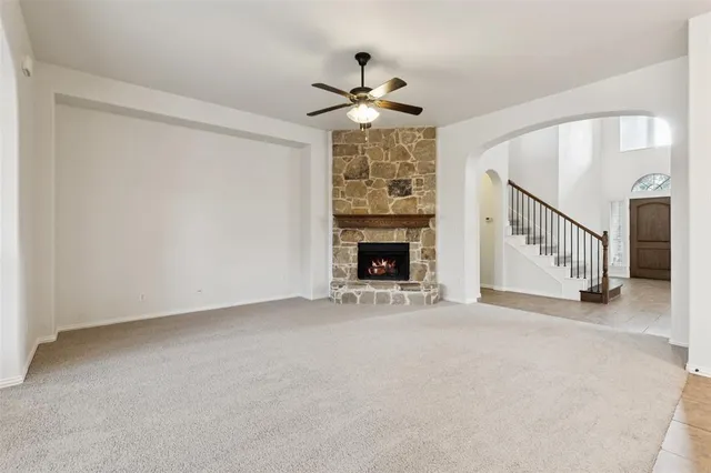 a view of an empty room with fireplace and a window