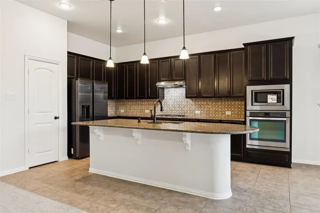a kitchen with stainless steel appliances granite countertop a refrigerator and a sink