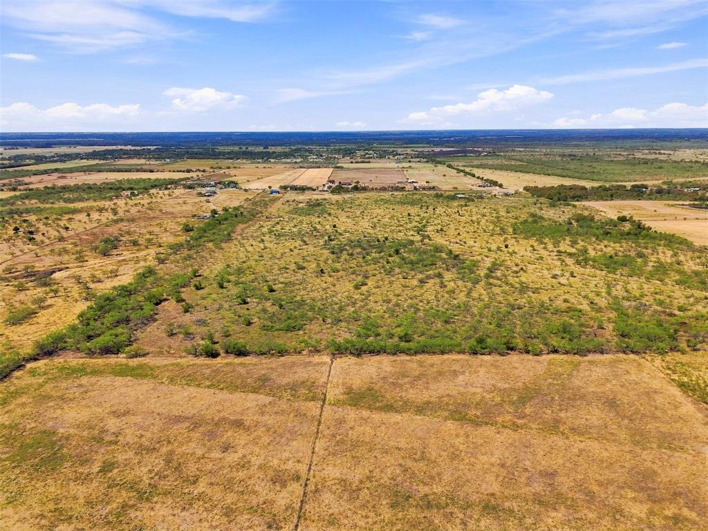 3208 Northeast County Road Powell, TX 75153 - Photo 27 of 29 Expansive rural landscape featuring a mix of open fields and natural vegetation under a clear sky