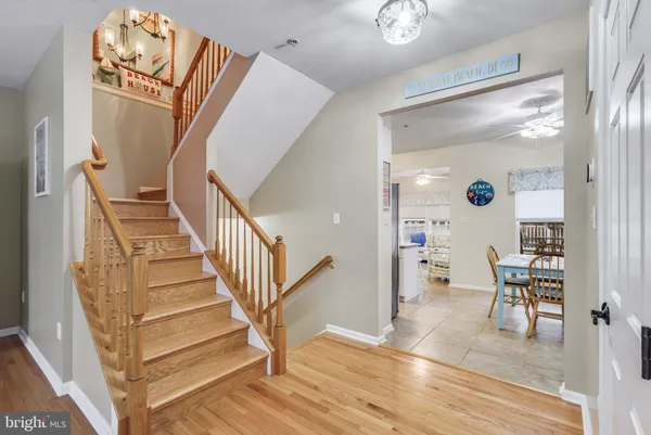 a kitchen with a refrigerator a stove a sink a dining table and chairs with wooden floor
