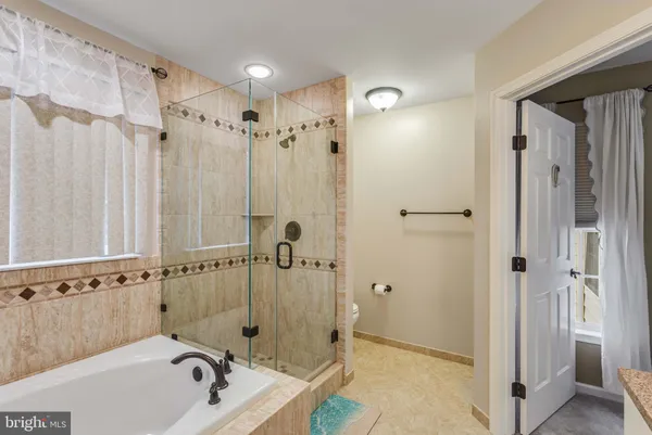 a bathroom with a tub sink and mirror