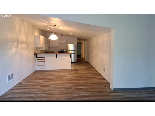 a kitchen view with wooden floor and cabinets