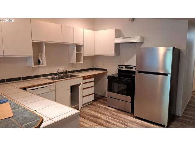 a kitchen with a refrigerator stove and cabinets