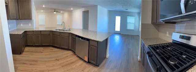 a kitchen with kitchen island granite countertop a stove and a sink
