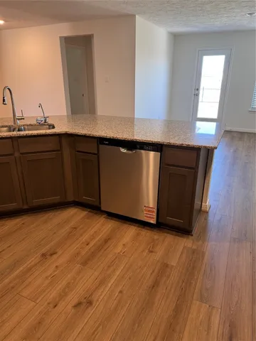 a kitchen with granite countertop wooden cabinets and a wooden floor
